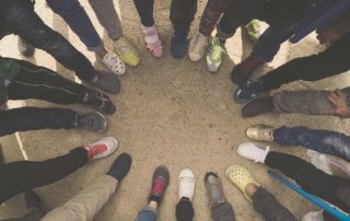 view of people's feet while standing in a circle